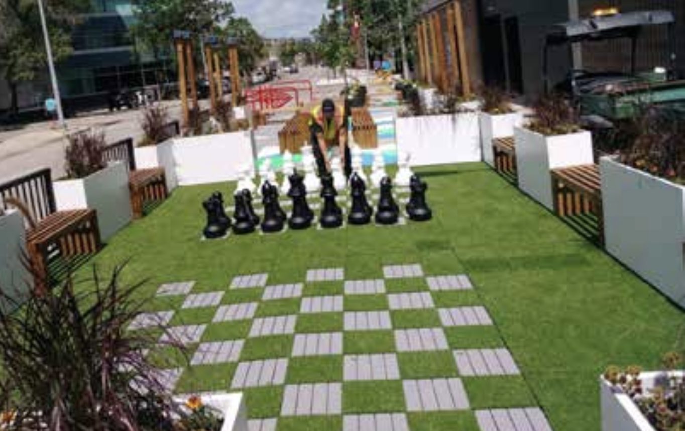 giant chess using astro turf in an unused parking lot